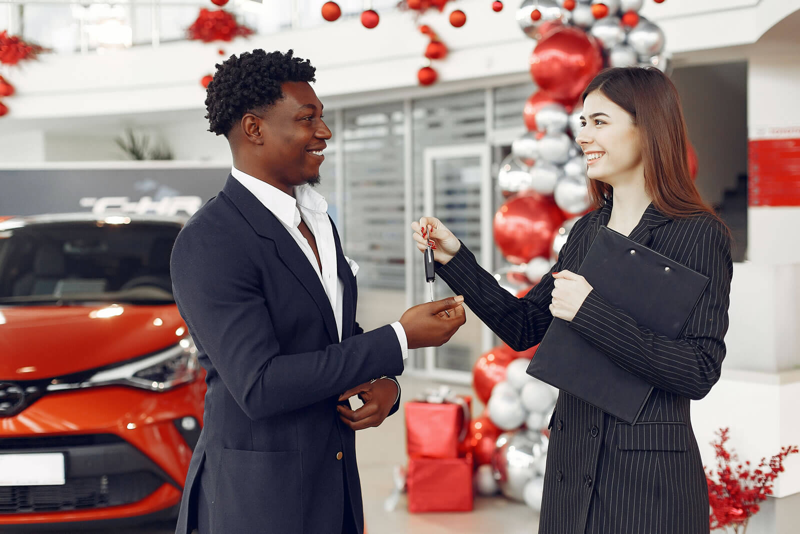 A car salesman handing over keys to a consumer